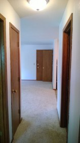 a hallway with two doors and a carpeted floor